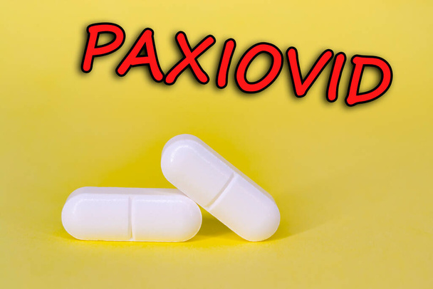 Paxiovid. Pfizer antiviral against Covid-19 (Coronavirus). Revolutionary pills for Covid. Background with pills on yellow background. Horizontal photography. Design with text. - Фото, зображення