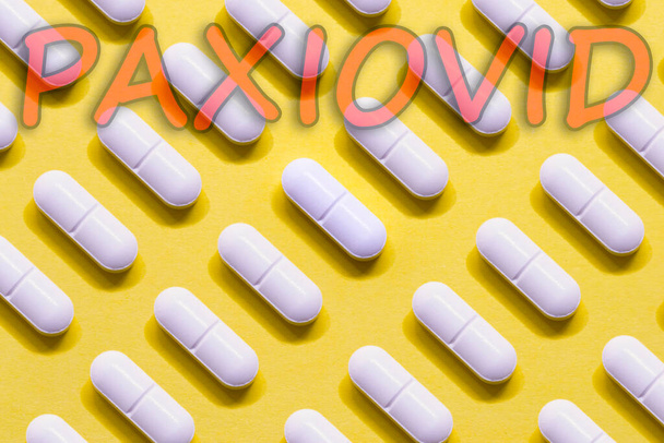 Paxiovid. Pfizer antiviral against Covid-19 (Coronavirus). Revolutionary pills for Covid. Background with pills on yellow background. Horizontal photography. Design with text. - Foto, Imagem
