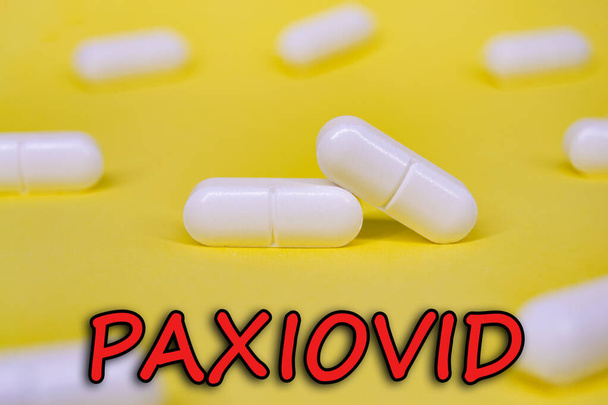 Paxiovid. Pfizer antiviral against Covid-19 (Coronavirus). Revolutionary pills for Covid. Background with pills on yellow background. Horizontal photography. Design with text. - Photo, Image