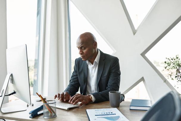 Focused black male businessman typing on computer - Photo, Image