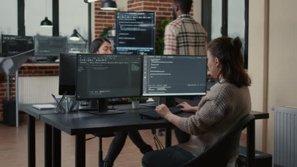 Junior developer putting laptop with source code on senior dev desk asking for opinion - Imágenes, Vídeo