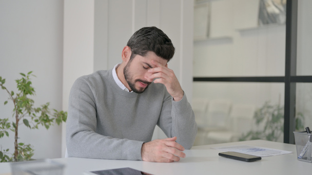 Αναστατωμένος νεαρός άνδρας που ανησυχεί ενώ κάθεται στο γραφείο - Φωτογραφία, εικόνα