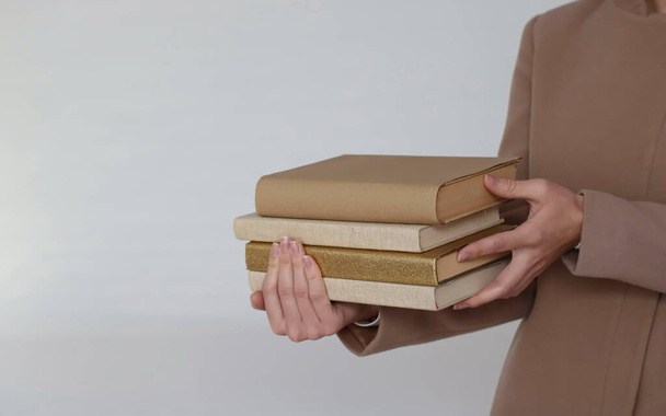 Une jeune belle fille tenant des livres dans ses mains - Photo, image