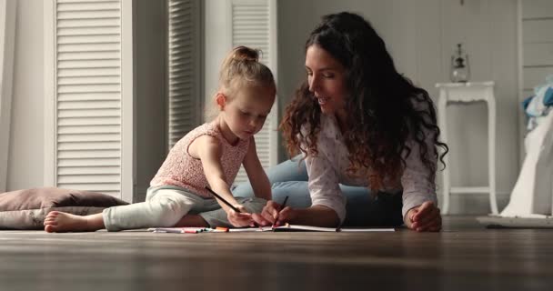 Hispanic woman her daughter drawing in album giving high five - Materiał filmowy, wideo