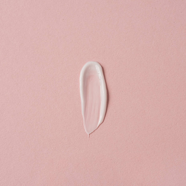 crema blanca sobre fondo rosa con espacio para copiar, concepto de cuidado de la piel - Foto, Imagen
