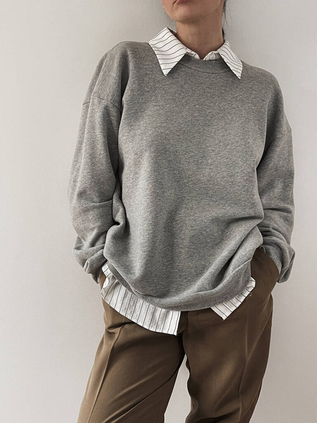 cropped shot of woman in gray sweatshirt and brown pants on white background - Foto, Imagem