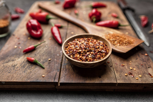 Variety of fresh and dried chili peppers on rustic background - Foto, Bild