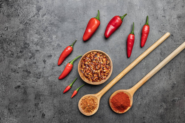 Variety of fresh and dried chili peppers on rustic background - Фото, зображення