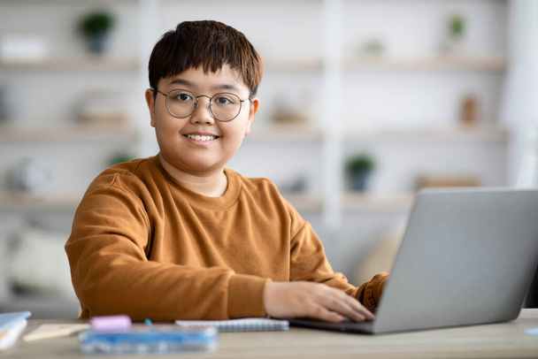 Смарт підліток хлопчик сидить перед комп'ютером, роблячи домашнє завдання
 - Фото, зображення