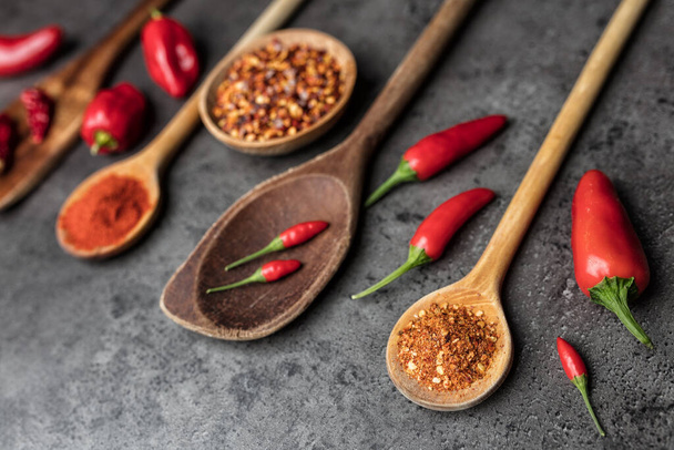 Variety of fresh and dried chili peppers on rustic background - Zdjęcie, obraz
