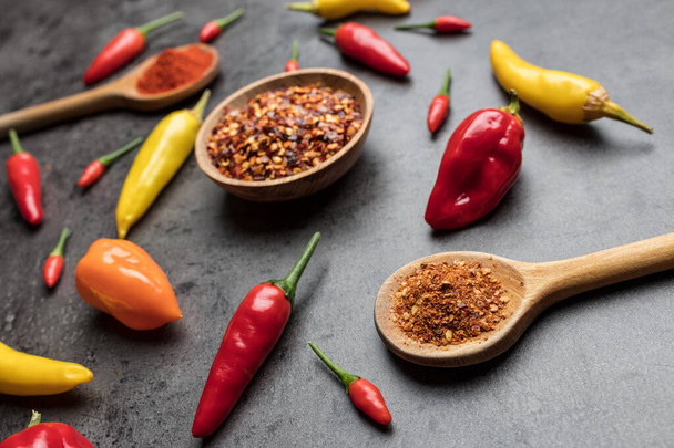 Variety of fresh and dried chili peppers on rustic background - Foto, Imagem