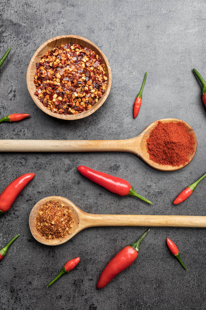 Variety of fresh and dried chili peppers on rustic background - Photo, image
