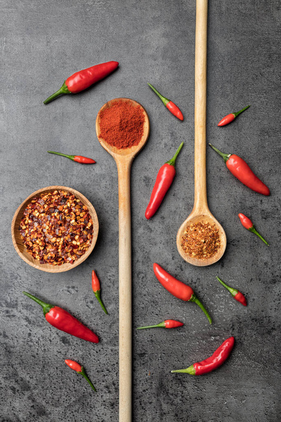 Variety of fresh and dried chili peppers on rustic background - 写真・画像