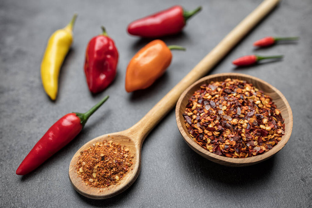Variety of fresh and dried chili peppers on rustic background - Foto, afbeelding