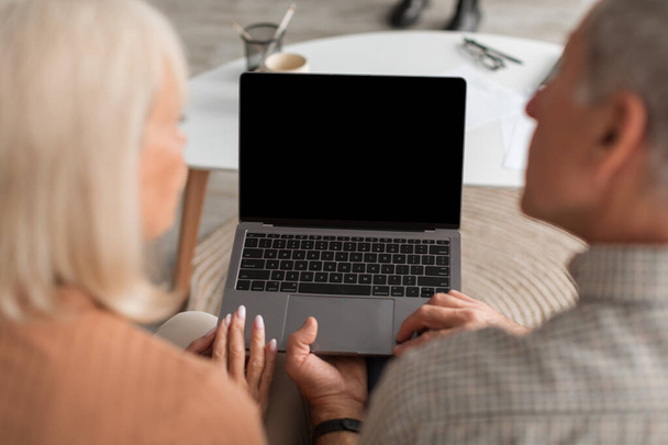 Back-View Of Senior Couple Using Laptop With Empty Screen Indoors - Valokuva, kuva