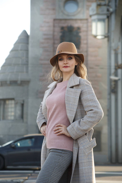 Elegant woman in coat and hat on the street. - 写真・画像