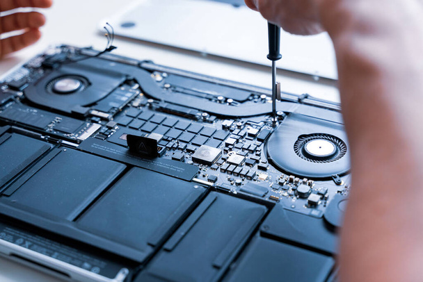 Computer repair man. Pc technician service with laptop on hardware background. Maintenance engineer support. Electronic technology development concept - Photo, Image