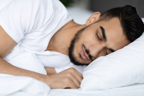 Primer plano disparo de guapo joven árabe durmiendo en cómoda cama - Foto, imagen