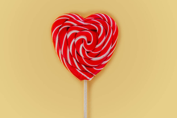 Roter Herzlutscher auf gelbem Hintergrund Liebe und Valentinstag Hintergrund - Foto, Bild