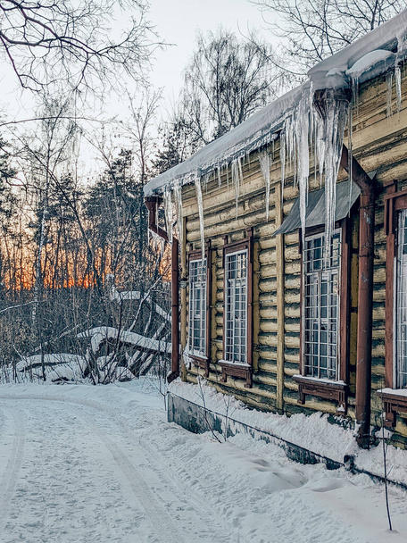 Haus im alten Gutshaus Bykovo, Russland. Eiszapfen und Schneehütte, alte Fenster mit Holzarchitraven - Foto, Bild