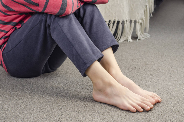 Girl's bare feet. Foot heel. Girl sitting on the floor. European - Photo, Image