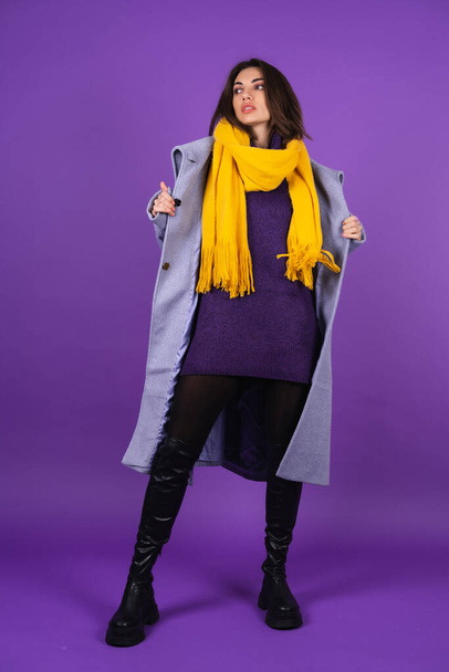グレーのコート、ニットのドレス、紫の背景に黄色のスカーフで若い女性、完全な成長、春の冬のスタイル - 写真・画像