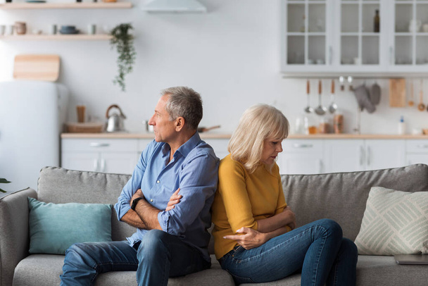 Unhappy Senior Spouses Sitting On Couch Back-To-Back After Quarrel Indoor - Foto, imagen
