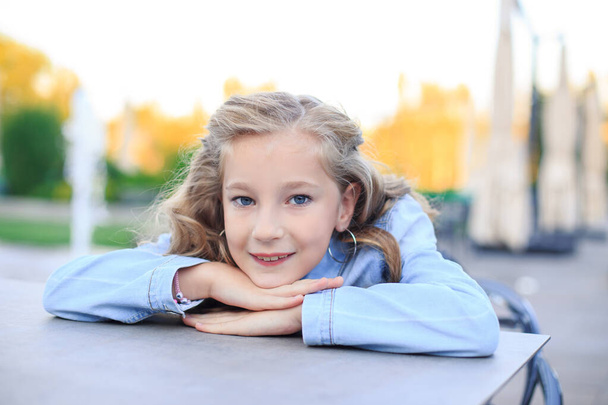 Portrait of a blond, blue-eyed girl in the park - Фото, зображення