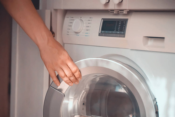 L'homme utilise la machine à laver moderne. - Photo, image