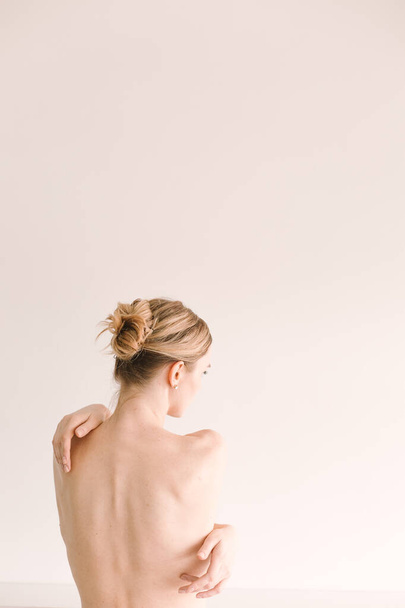 girl with naked back hair tied in a pigtail white backgroun - Fotoğraf, Görsel