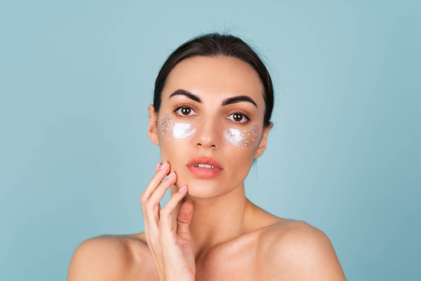 Close beauty portrait of a topless woman with perfect skin and natural make-up, shiny patches under the eyes, to moisturize the skin and relieve puffiness of the face - Foto, Imagen