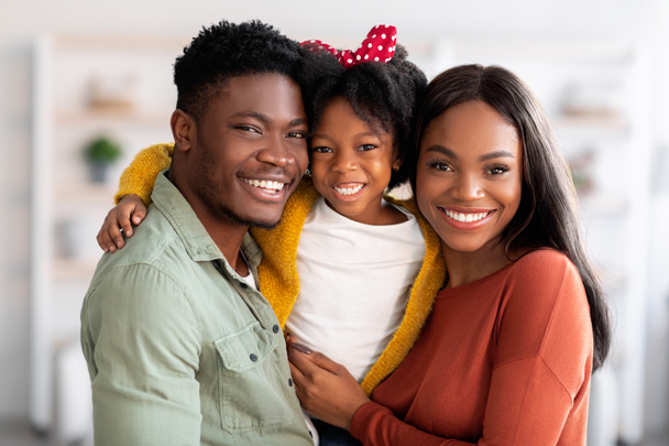 Happy Family. Portrait Of Smiling Black Parents And Their Cute Little Daughter - Fotó, kép