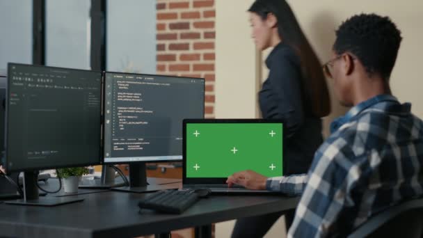 Database ontwerper schrijven code met behulp van laptop met groene scherm chroma sleutel mockup zitten aan het bureau - Video