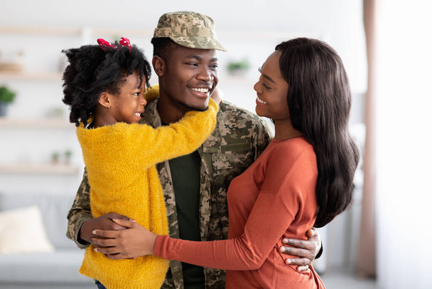 feliz negro esposa y hija bienvenida militar padre en casa después de ejército - Foto, Imagen