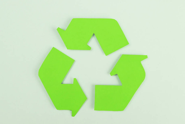 sign of recycling made of green paper, concept of protection, preservation of the environment - Foto, afbeelding