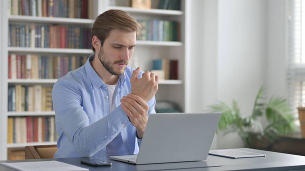 Homem com dor de pulso ao usar no laptop  - Foto, Imagem
