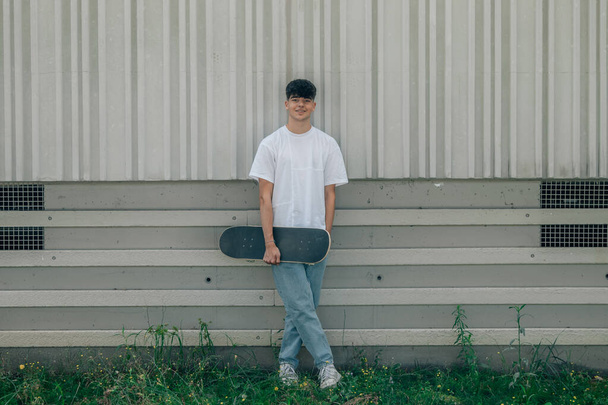 teenager leaning on the street wall with skateboard - Valokuva, kuva