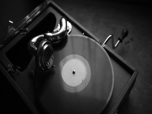 An old wind-up gramophone with a vinyl record. Black and white retro video. Vintage ways of listening to music. - Video