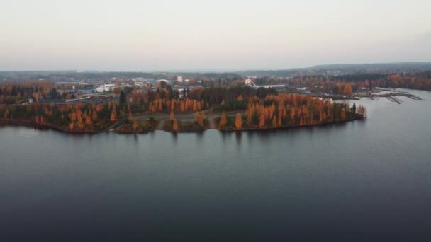 Drónfelvétel az Oulujarvi-tóról és az őszi erdőről Kajaani körül, Közép-Finnországban. Drónfelvételek a narancssárgával színezett lombhullató erdő körül. Napnyugta. 4k videó - Felvétel, videó