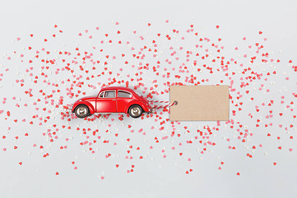 Red retro toy car with a paper card. Valentine's day, 8 March, Happy Women's Day. - Φωτογραφία, εικόνα