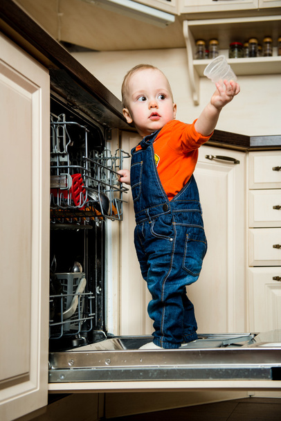 Baby helping unload dishwasher - Photo, image