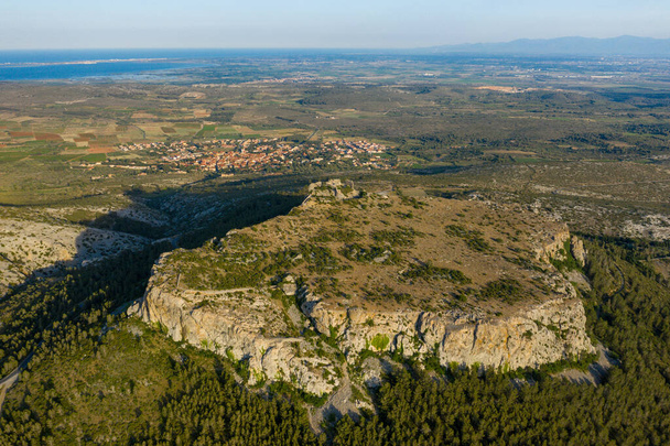 Dieses Landschaftsbild wurde im Sommer in Europa, in Frankreich, in Okzitanien, in den östlichen Pyrenäen aufgenommen. Wir sehen das Chateau de Opoul Perillos auf seinem trockenen Berg, unter der Sonne. - Foto, Bild