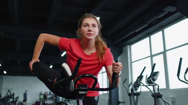 Csoportja lányok elvégzi nyújtás edzés edzés kardio rutin kerékpár szimulátorok ciklus képzés - Fotó, kép