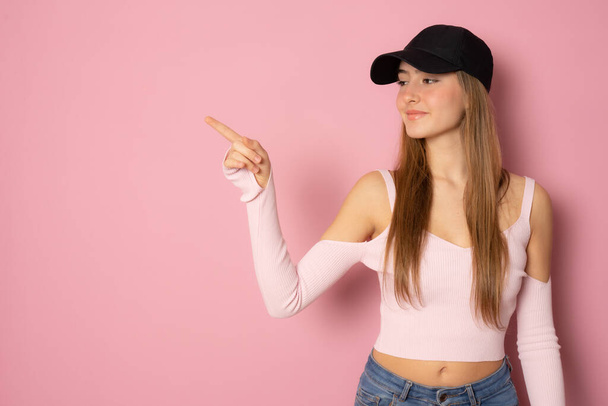 Young woman wearing sport clothing pointing finger up isolated over pink background. - Photo, Image
