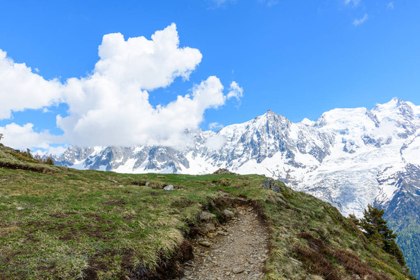 Tato fotografie krajiny byla pořízena v Evropě, ve Francii, v Alpách, směrem na Chamonix, v létě. Vidíme turistickou stezku na vrcholu Aiguillette des Houches v masivu Mont Blanc, pod sluncem. - Fotografie, Obrázek