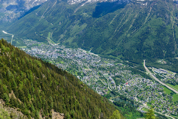 Tato fotografie krajiny byla pořízena v Evropě, ve Francii, v Alpách, směrem na Chamonix, v létě. Vidíme město Chamonix v údolí Mont Blanc v masivu Mont Blanc, pod sluncem. - Fotografie, Obrázek
