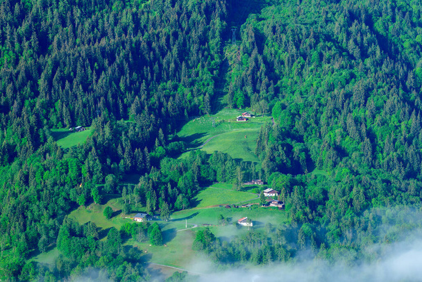 To zdjęcie krajobrazowe zostało zrobione latem w Europie, we Francji, w Alpach, w kierunku Chamonix. Widzimy zieloną górę w kierunku Chamonix w masywie Mont Blanc, pod Słońcem.. - Zdjęcie, obraz