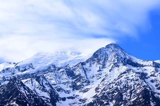 Αυτή η φωτογραφία τοπίου τραβήχτηκε στην Ευρώπη, στη Γαλλία, στις Άλπεις, προς το Chamonix, το καλοκαίρι. Μπορούμε να δούμε το Mont Blanc και το Aiguille du Gouter στην ομίχλη, κάτω από τον ήλιο. - Φωτογραφία, εικόνα