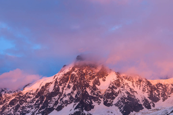 To zdjęcie krajobrazowe zostało zrobione latem w Europie, we Francji, w Alpach, w kierunku Chamonix. Widzimy Aiguille du Midi o zmroku w masywie Mont Blanc, pod Słońcem. - Zdjęcie, obraz