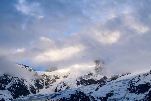 Tato fotografie krajiny byla pořízena v Evropě, ve Francii, v Alpách, směrem na Chamonix, v létě. Vidíme Mont Blanc du Tacul zahalený v oblacích. - Fotografie, Obrázek